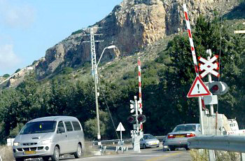 תמונה לשאלת תיאוריה: איזו חובה מוטלת על נהג המתקרב למפגש מסילת ברזל המוגן במחסום ומוצב בו רמזור?