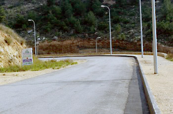 תמונה לשאלת תיאוריה: בתמונה שלפניך יש כמה גורמי דרך. מה צריכה להיות תגובת הנהג בהתקרבו למקום?