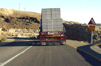 תמונה לשאלת תיאוריה: נסיעה בעקבות הרכב הכבד ובתנאי הדרך הנתונים מחייבת את הנוהג ברכב: